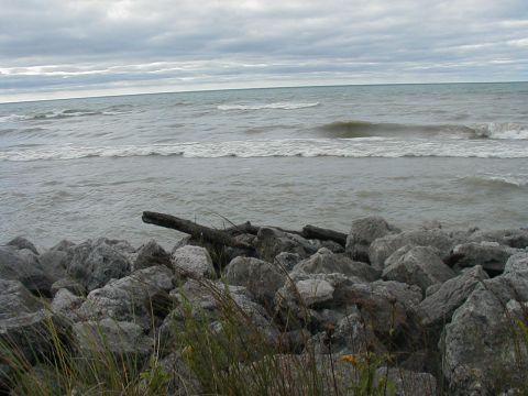 1997 Ford Taurus - Waves crash on a rocky shore under an overcast sky. A watermark is visible in the lower right corner.