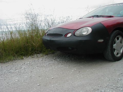 1997 Ford Taurus - A 1997 Ford Taurus is parked on a gravel road with a car bra covering its front end.