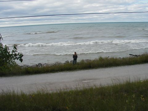 1997 Ford Taurus - A person stands by the water's edge on a cloudy day.