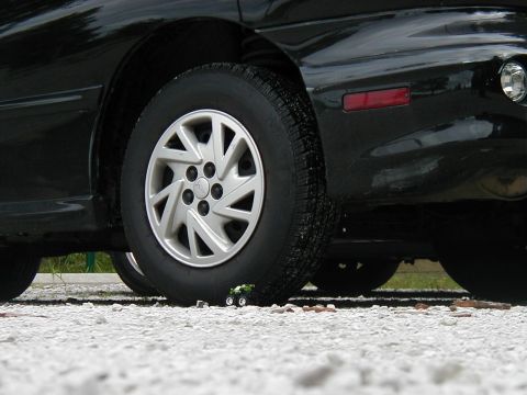1997 Ford Taurus - A miniature vehicle is dwarfed by the tire of a full-sized automobile.