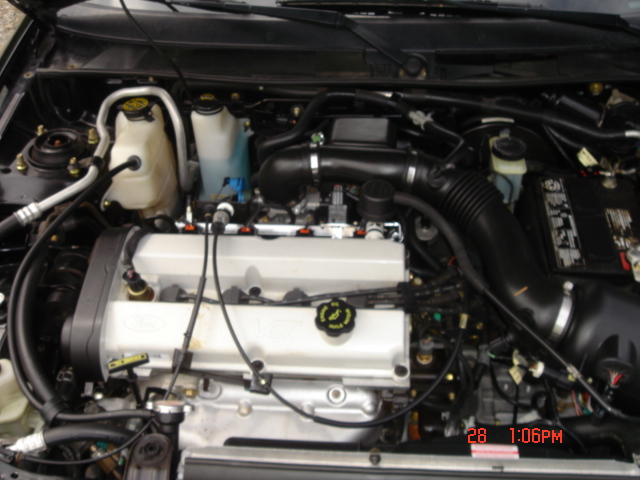 1999 Ford Escort engine bay with visible Ford logo on valve cover