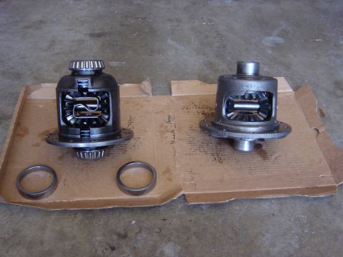 1990 Ford Bronco - Two open differentials and bearing races are laid out on a piece of cardboard.