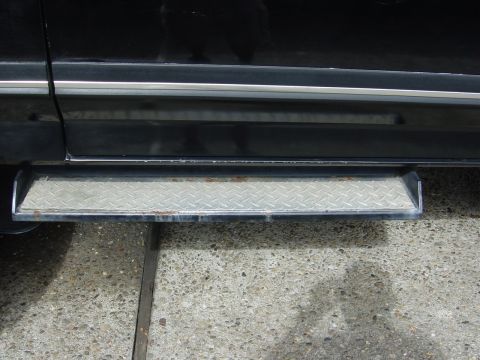 1990 Ford Bronco - Side view of a diamond plate step bar on a black vehicle.