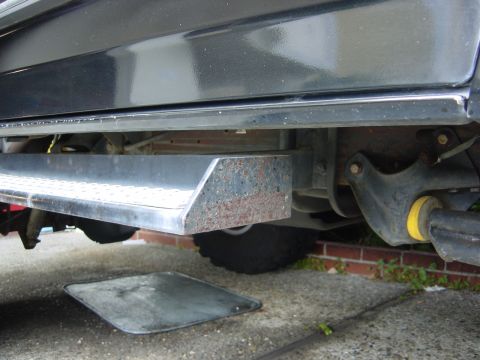 1990 Ford Bronco - The underside of a vehicle is visible, a running board and suspension parts.