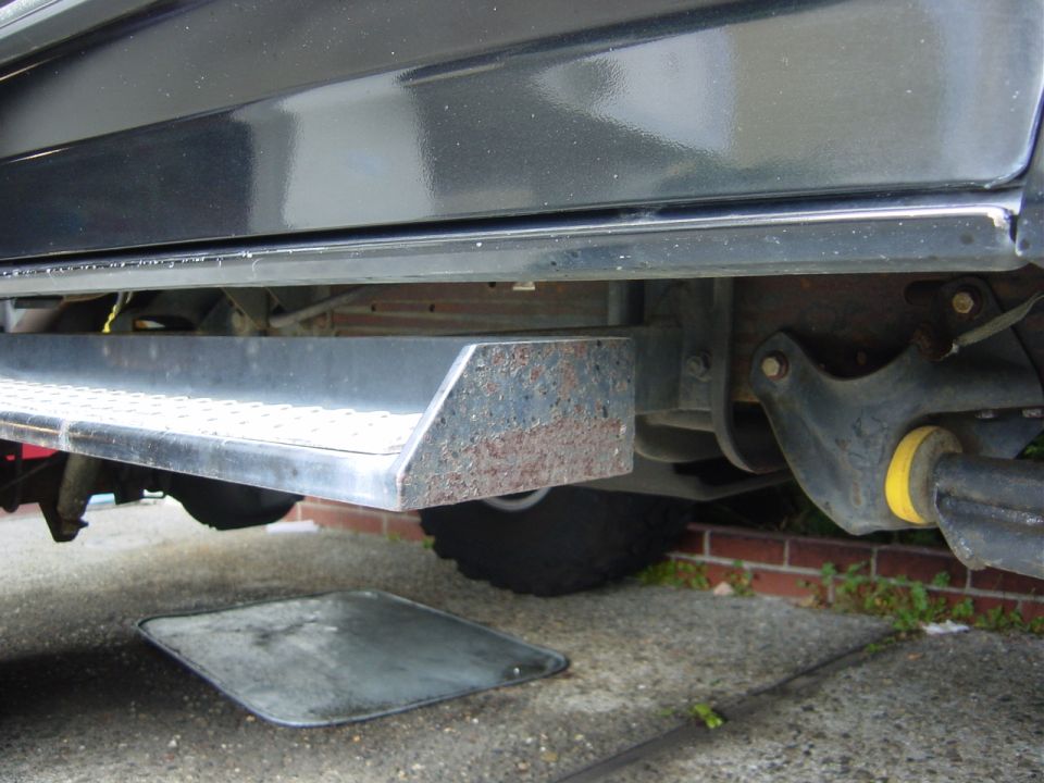 close-up of a vehicle's side, showing the running board and undercarriage components
