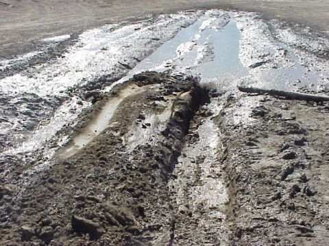 1989 Ford Bronco - A muddy track with deep ruts and puddles suggests a challenging off-road situation.