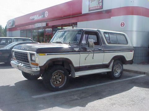 1989 Ford Bronco - Driver-side front three-quarter view of a two-tone brown-over-white late-1970s full-size Ford Bronco parked at a Texaco Food Mart convenien…