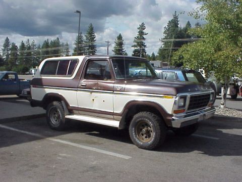 1989 Ford Bronco - This two-tone Ford Bronco is parked in a lot under a cloudy sky.