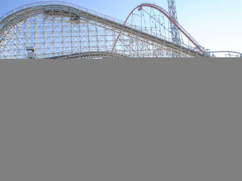 1993 Ford Taurus - A large wooden roller coaster with a red track section is visible against a clear blue sky.