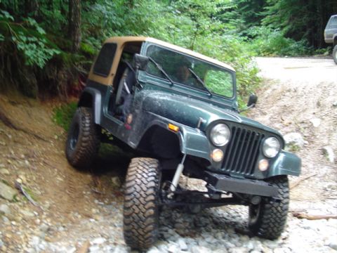 1993 Ford Bronco - Jeep CJ-7 navigating a challenging off-road trail with steep inclines and loose rocks.