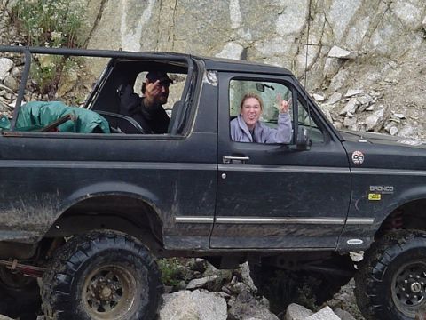 1993 Ford Bronco - A black 1993 Ford Bronco navigates a rocky trail with two occupants.