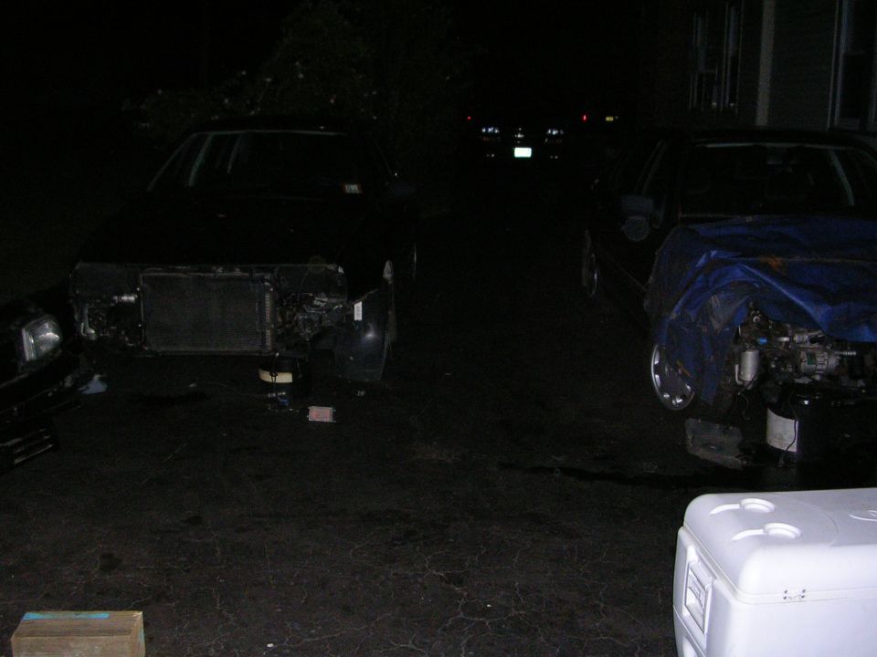 two cars at night, both missing front ends and radiators