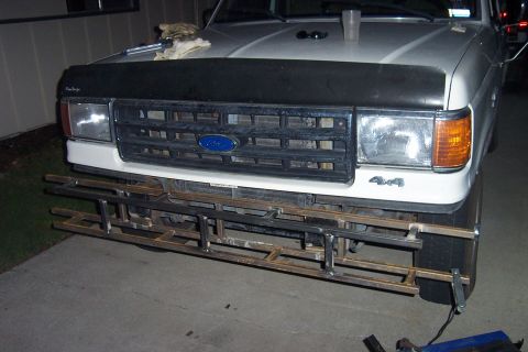 1990 Ford Bronco - A custom metal bumper is being welded onto the front of a Ford truck.