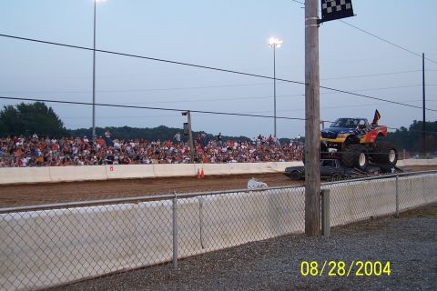 1979 Ford Bronco II - A monster truck performs at an event with spectators in the background.