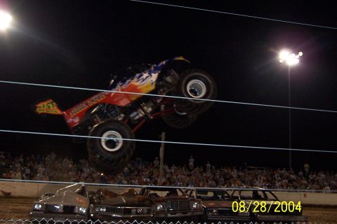1979 Ford Bronco II - Monster truck performing a jump over wrecked cars during an event on 08/28/2004.