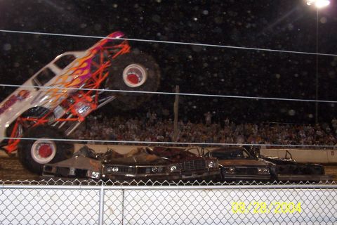 1979 Ford Bronco II - A monster truck is shown crushing several cars during an event.