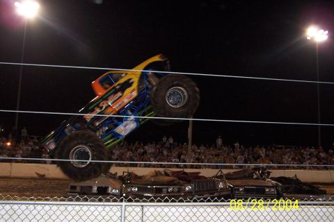 1979 Ford Bronco II - The "Black Stallion" monster truck performs a stunt, crushing several cars in front of a large crowd.