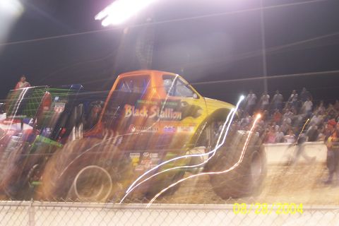 1979 Ford Bronco II - A monster truck with "Black Stallion" written on its side is shown in motion at an event.