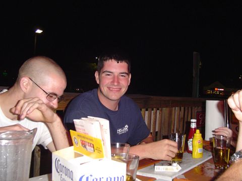 1979 Ford Bronco - Two men sit at an outdoor patio table at night with beer glasses, a pitcher, a Corona table caddy and ketchup and mustard bottles. No vehic…