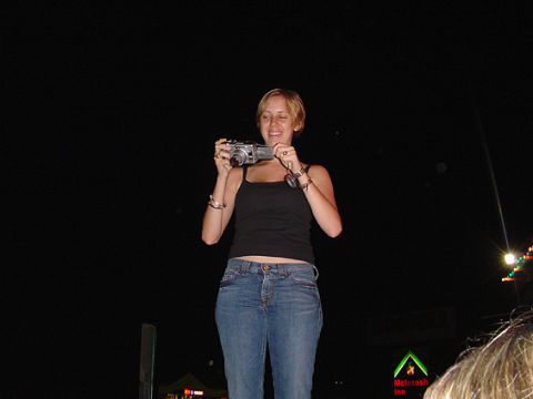 1979 Ford Bronco - A woman is taking a photo with a digital camera at night.