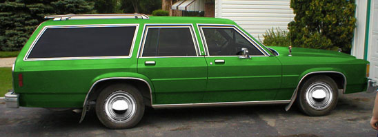 Green 1987 Ford LTD Crown Victoria station wagon, right side view, parked on a driveway