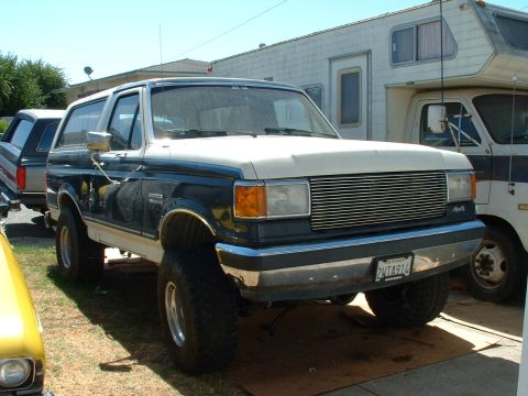 1990 Ford Bronco - Lifted 1990 Ford Bronco in a driveway with other vehicles and an RV.
