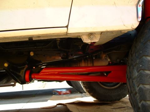 1990 Ford Bronco - Close-up view of aftermarket suspension parts installed on a vehicle's undercarriage.