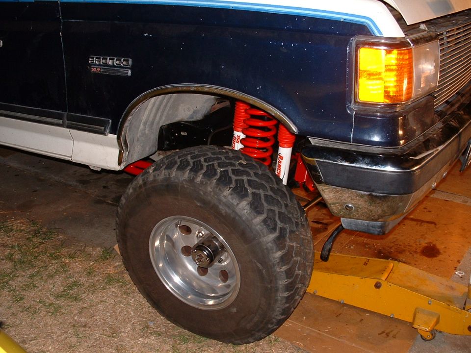 1990 Ford Bronco front fender, tire, and lift kit with red Ranch shocks