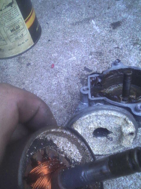 1987 Lincoln Town Car - Disassembled automotive component showing internal wear and debris, with a can in the background.