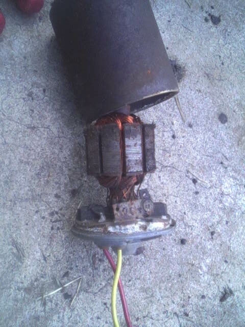 1987 Lincoln Town Car - A disassembled motor armature with visible copper windings and electrical wires lies on a concrete surface.