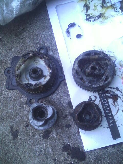 1987 Lincoln Town Car - Several damaged engine components are laid out on a surface, with a piece of paper showing partial text.