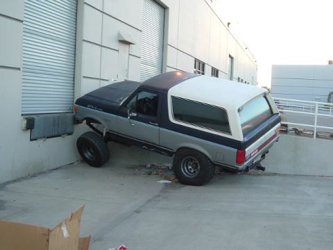 1989 Ford Bronco - This 1989 Ford Bronco appears to be stuck in a loading dock, with its front end firmly lodged against the wall.