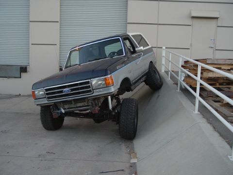 1989 Ford Bronco - Modified Ford Bronco with lifted suspension navigates a steep concrete incline.