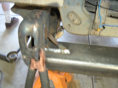 1989 Ford Bronco - Custom metalwork is being performed on the vehicle's frame, with a focus on a bracket attachment point.