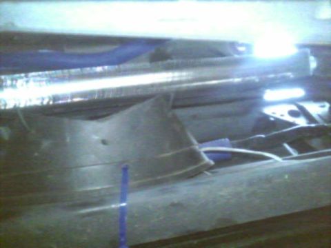 1987 Lincoln Town Car - Close-up view of engine components, including a blue hose and a metal bar, with some wiring visible.