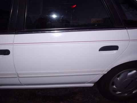 1998 Ford Taurus - The side profile of a white sedan, with a visible wheel cover indicating 'TAURUS'.