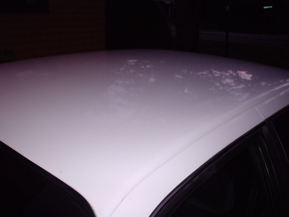 White car roof with reflections. Supermotors.net logo visible