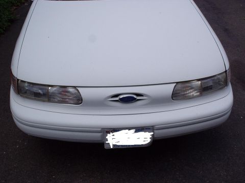 1998 Ford Taurus - The front of a white 1996 Ford Taurus is shown, its headlights and a license plate.