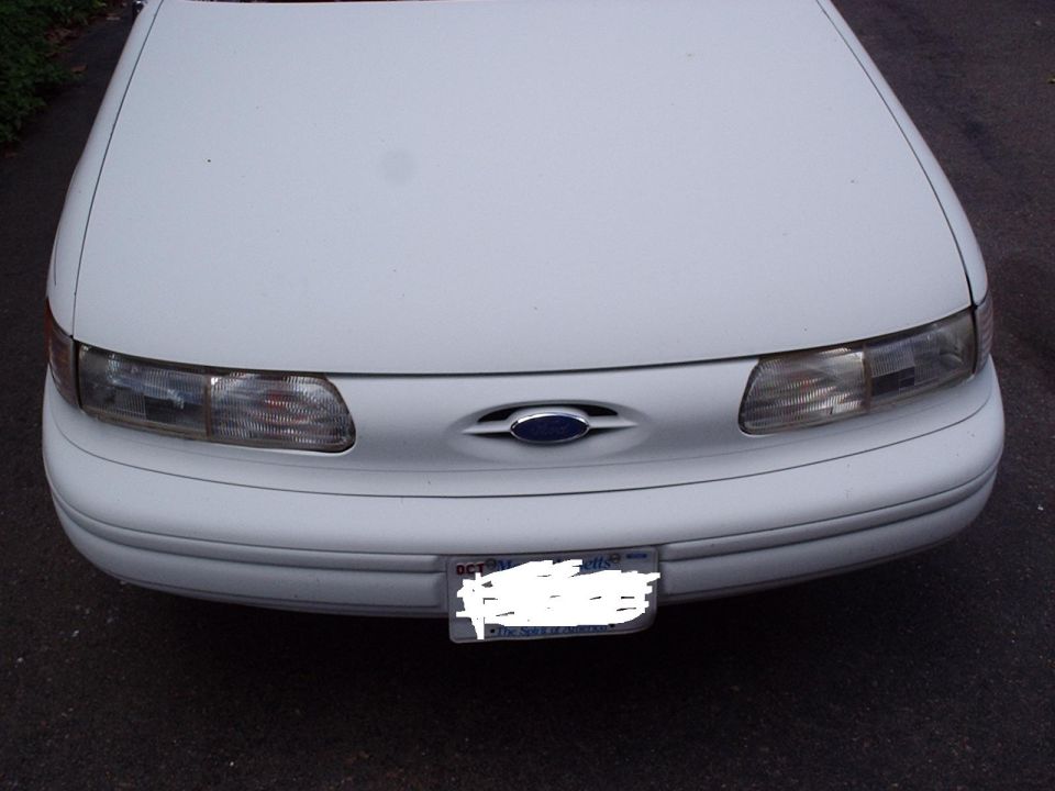 White 1996 Ford Taurus front end with headlights and license plate visible
