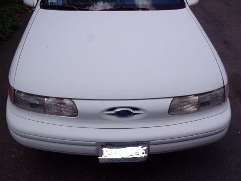 1998 Ford Taurus - Front view of a white 1998 Ford Taurus, showing the grille, headlights, and license plate.