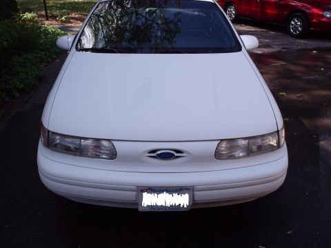 1998 Ford Taurus - Front view of a white 1998 Ford Taurus, with another vehicle in the background.