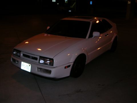 1990 Volkswagen Corrado - A white 1990 Volkswagen Corrado is parked outside at night under artificial lighting.