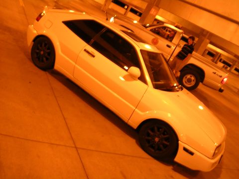 1990 Volkswagen Corrado - A white 1990 Volkswagen Corrado coupe is parked next to a pickup truck in a garage.