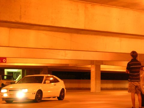 1990 Volkswagen Corrado - A white 1990 Volkswagen Corrado is parked in a dimly lit garage with its headlights illuminated.