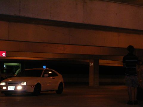 1990 Volkswagen Corrado - A white 1990 Volkswagen Corrado is parked in a garage, illuminated by its headlights and a blue light on its roof.