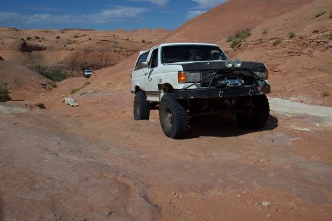 1990 Ford Bronco - This 1990 Ford Bronco navigates a rocky desert trail under a clear blue sky.