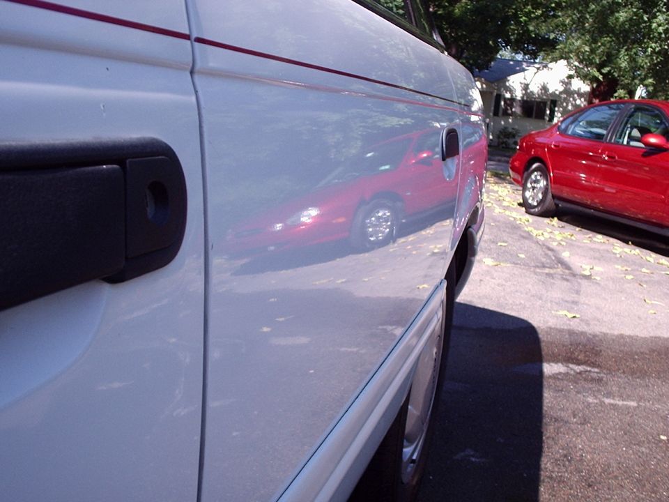White van side door, reflection of red car