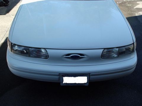 1998 Ford Taurus - Front view of a white 1998 Ford Taurus, displaying its headlights and grille.