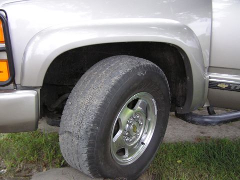 2000 Chevrolet Tahoe - This photo shows the front wheel and fender of a Chevrolet truck, likely a Tahoe, with a visible 'Tahoe' badge.
