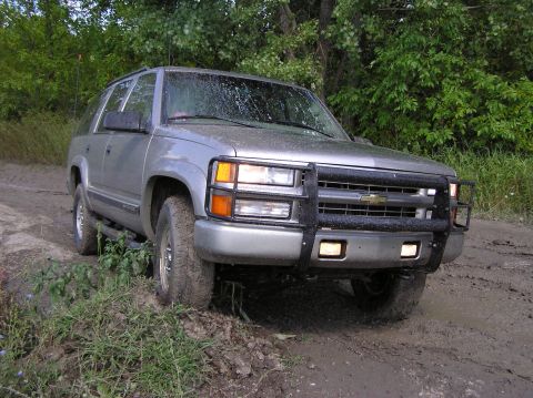 2000 Chevrolet Tahoe - This silver SUV, likely a 1995 model, navigates a muddy, off-road path.